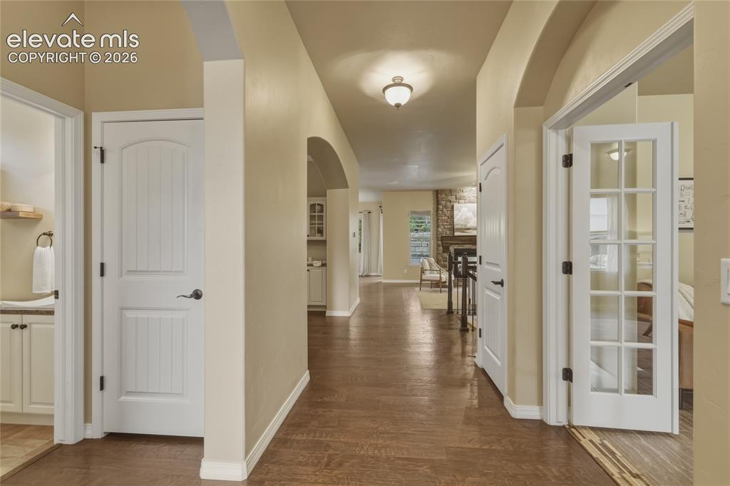 Image 4 of 49: Wood-finish flooring throughout, arched doorways, white interior doors, and