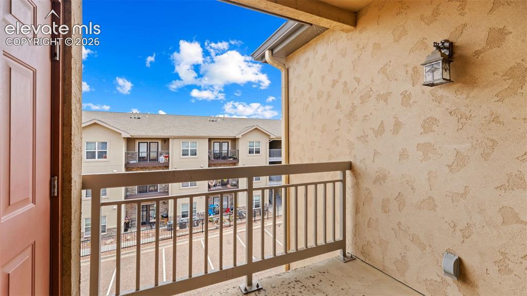 Image 16 of 33: Private balcony featuring a stucco wall, metal railing, and an exterior wal