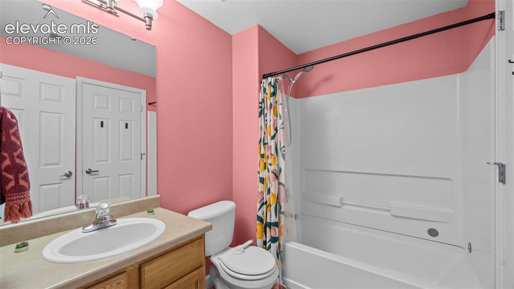 Image 20 of 33: Bathroom featuring a single vanity with a laminate countertop, white oval s