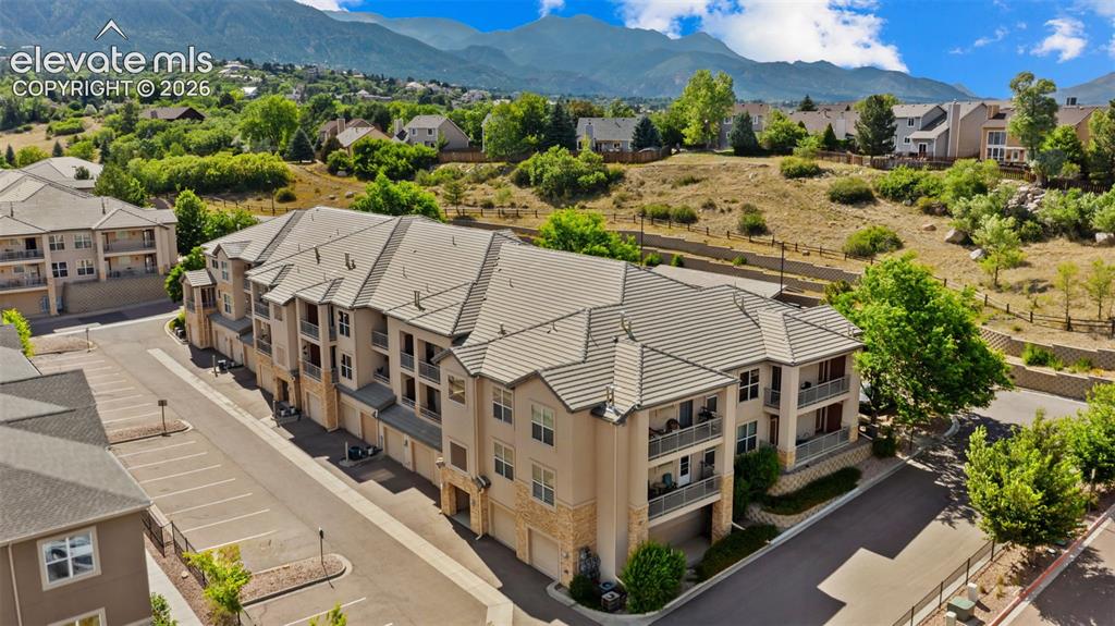Image 27 of 33: Multi-story residential building featuring a neutral-toned stucco and stone