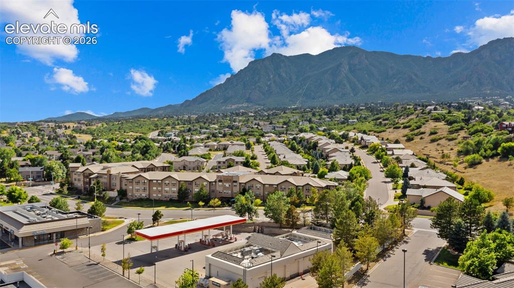 Image 28 of 33: Expansive mountain scenery framing a residential community with mature tree