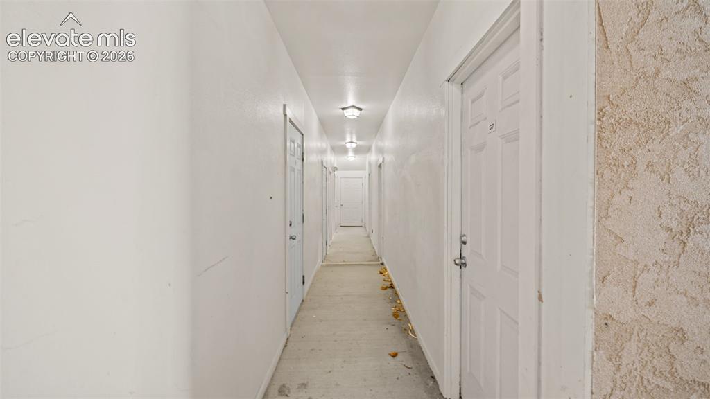 Image 31 of 33: Basement hallway leading to storage unit.