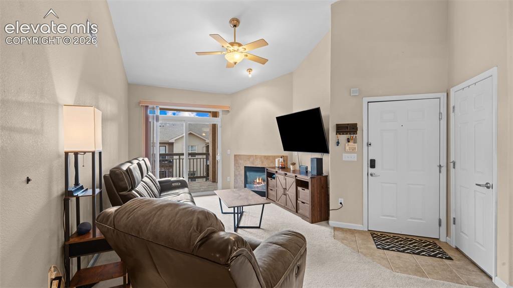 Image 7 of 33: Vaulted ceiling living space featuring a ceiling fan with integrated lighti