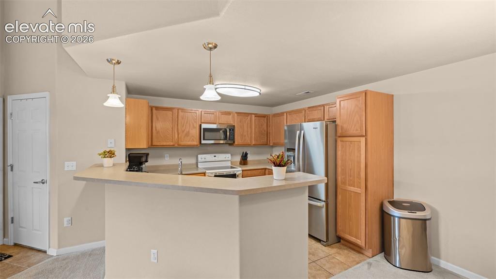 Image 8 of 33: Kitchen featuring wood-finish cabinetry, stainless steel appliances, a brea