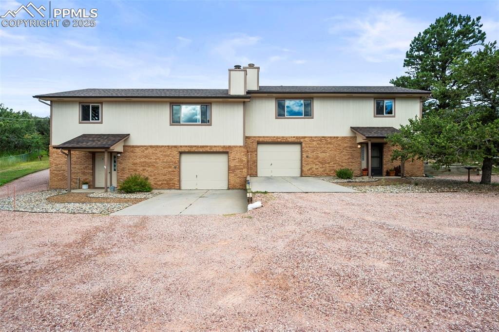 Caption: Front elevation showing concrete parking for each unit as well as extra graveled parking areas for e