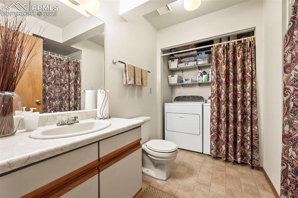 Image 16 of 22: Lower level bathroom also housing laundry hookup.
