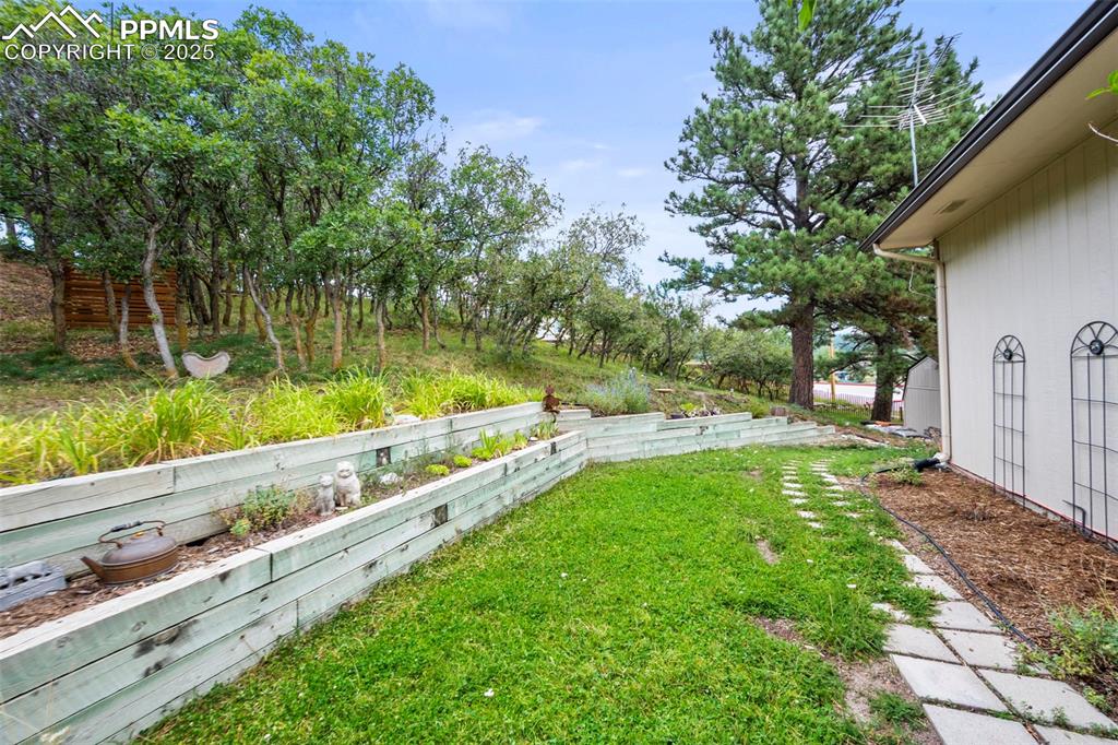Image 18 of 22: View of yard from Unit A deck. Landscaping and shed provide privacy from th