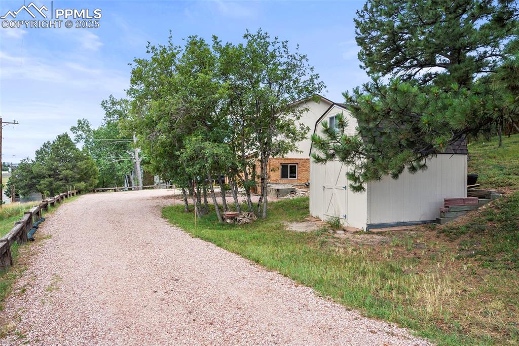 Image 2 of 22: View of entry off Roberts Dr showing tuff shed for extra storage.  Building