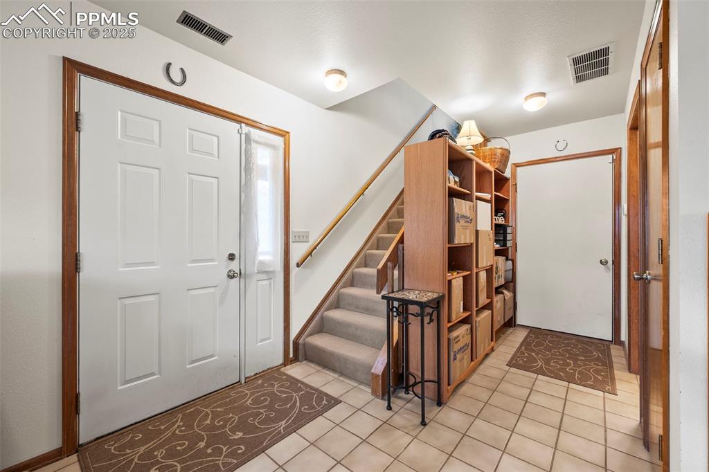 Image 7 of 22: Entryway featuring lower level bath on right, door to garage straight ahead