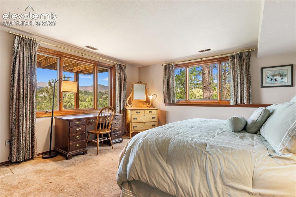 Image 33 of 50: Basement bedroom with garden level windows to let the views in