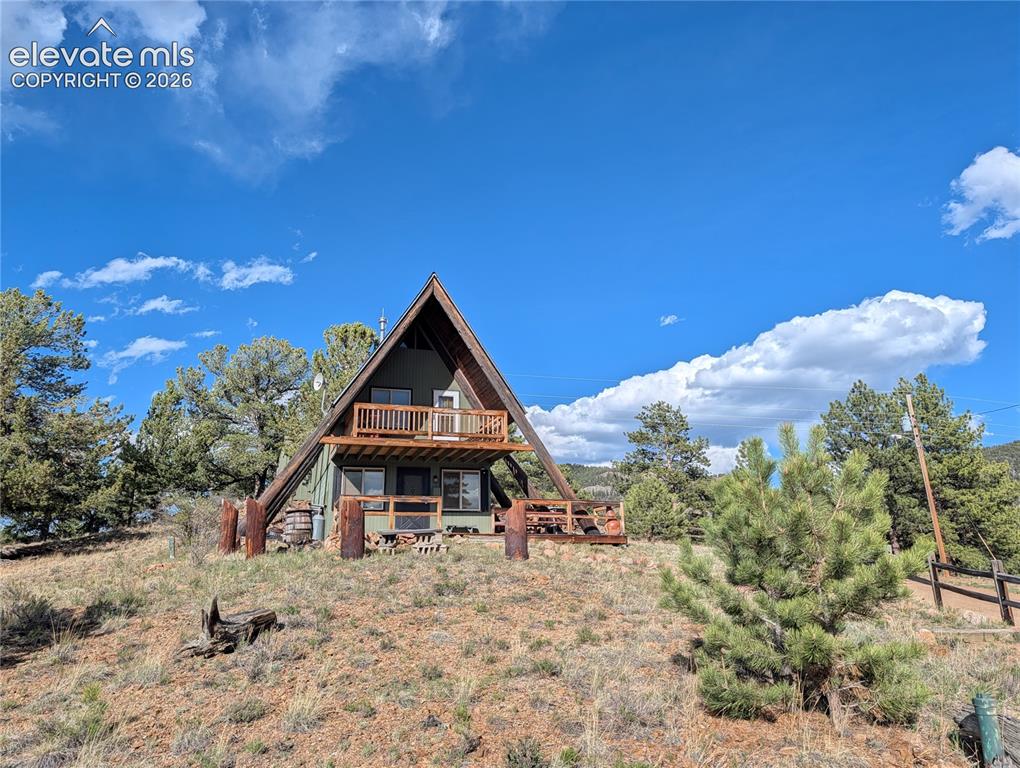 Image 2 of 42: A-frame dwelling featuring a prominent pitched roofline, an upper-level bal