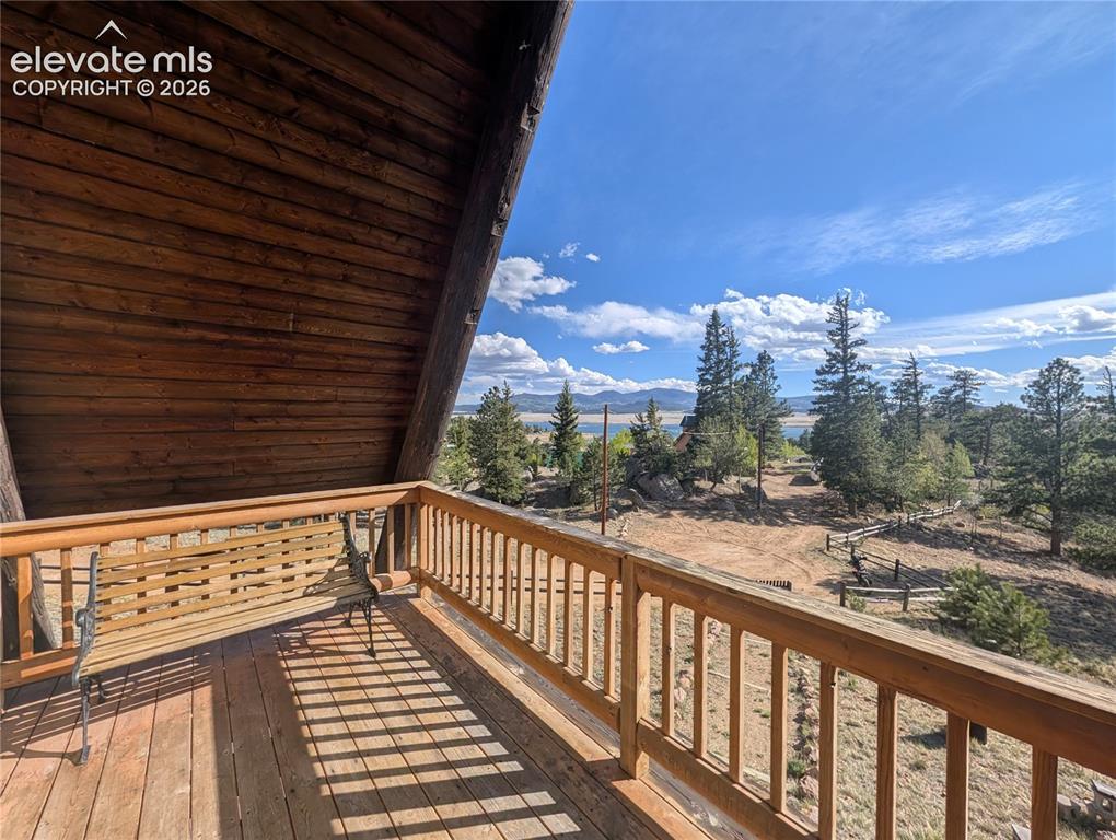 Image 22 of 42: Expansive wood deck with a full wood railing, featuring a sloped wood plank