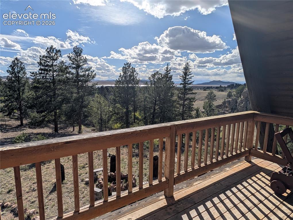 Image 23 of 42: Expansive outdoor deck with natural wood railing, offering broad vistas of