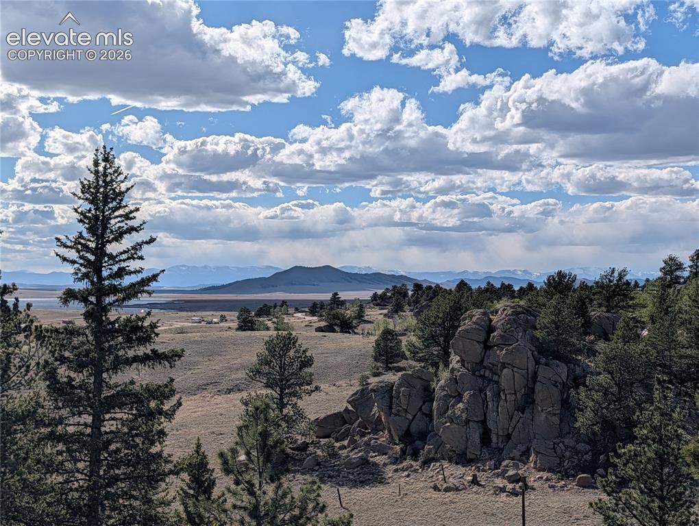 Image 30 of 42: Expansive mountain landscape featuring prominent rock formations, mature ev