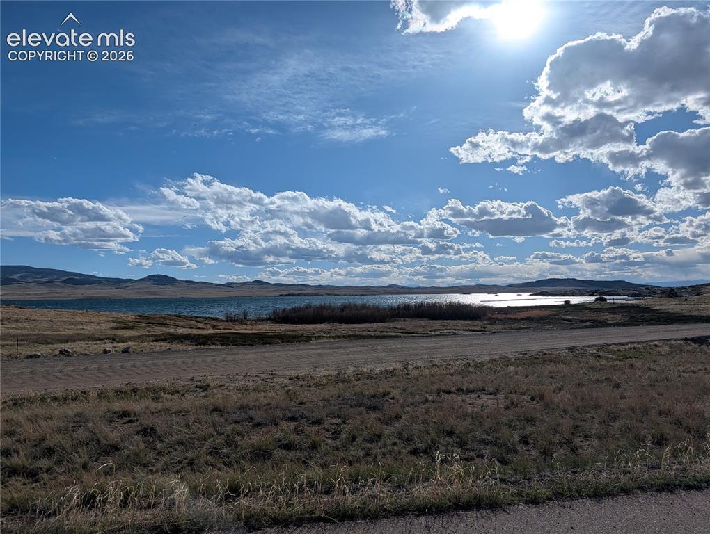 Image 39 of 42: Expansive natural landscape featuring a prominent body of water, distant hi