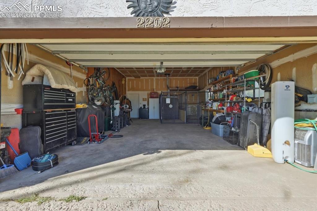 Image 22 of 49: Attached 2 car garage has a door that leads to the family room and another