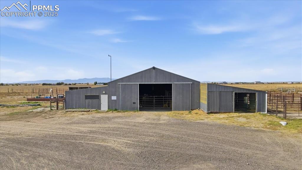 Image 33 of 49: Barn with 10 indoor stalls with outside runs, 5 stalls in the center barn