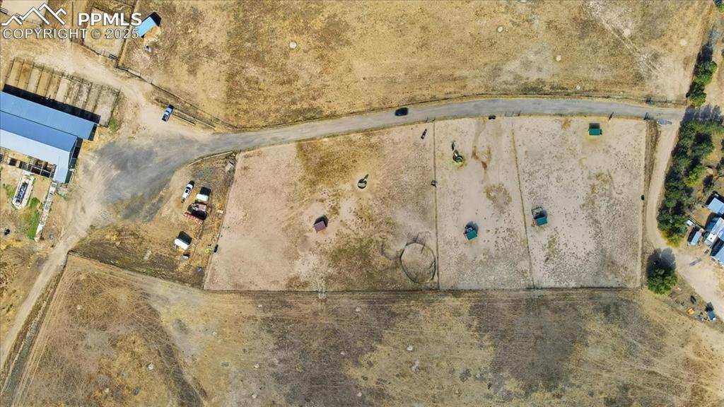 Image 44 of 49: Arial view of road from the house to the barn. There are boarding paddocks,