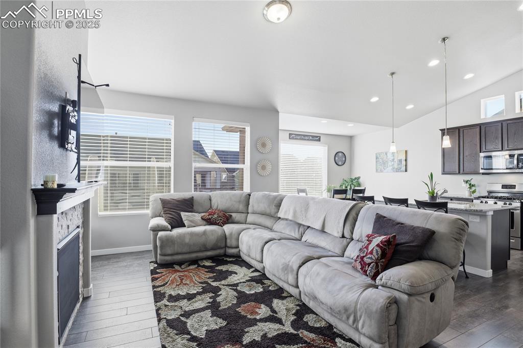 Image 5 of 42: LIVING AREA WITH A GAS FIREPLACE THAT FLOWS INTO THE DINING ROOM AND KITCHE