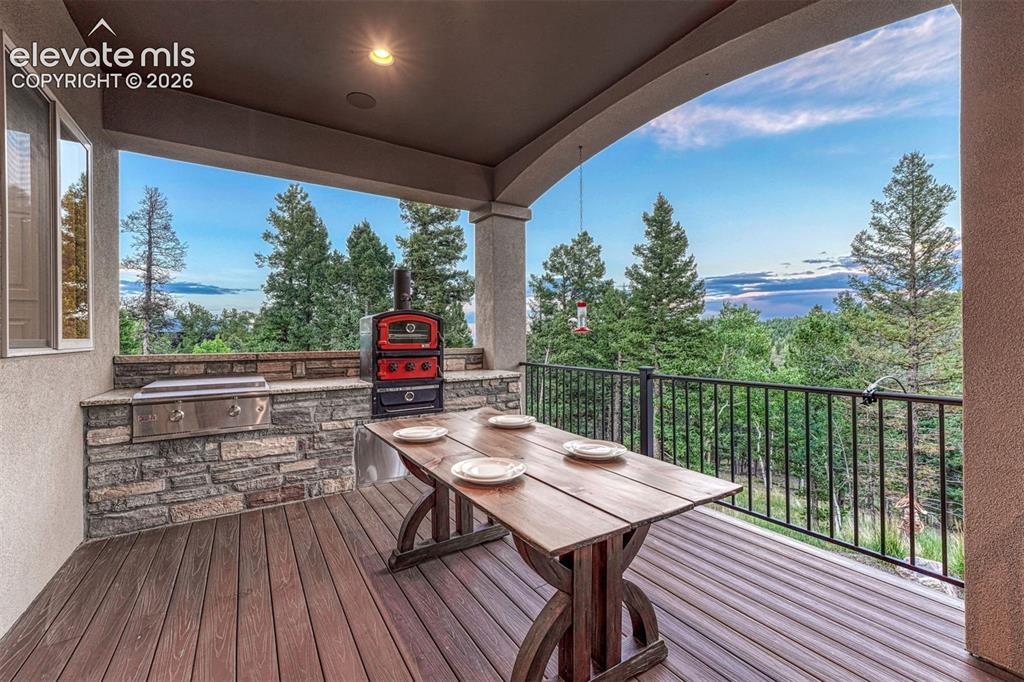 Image 38 of 50: Covered deck with pizza oven and gas grill