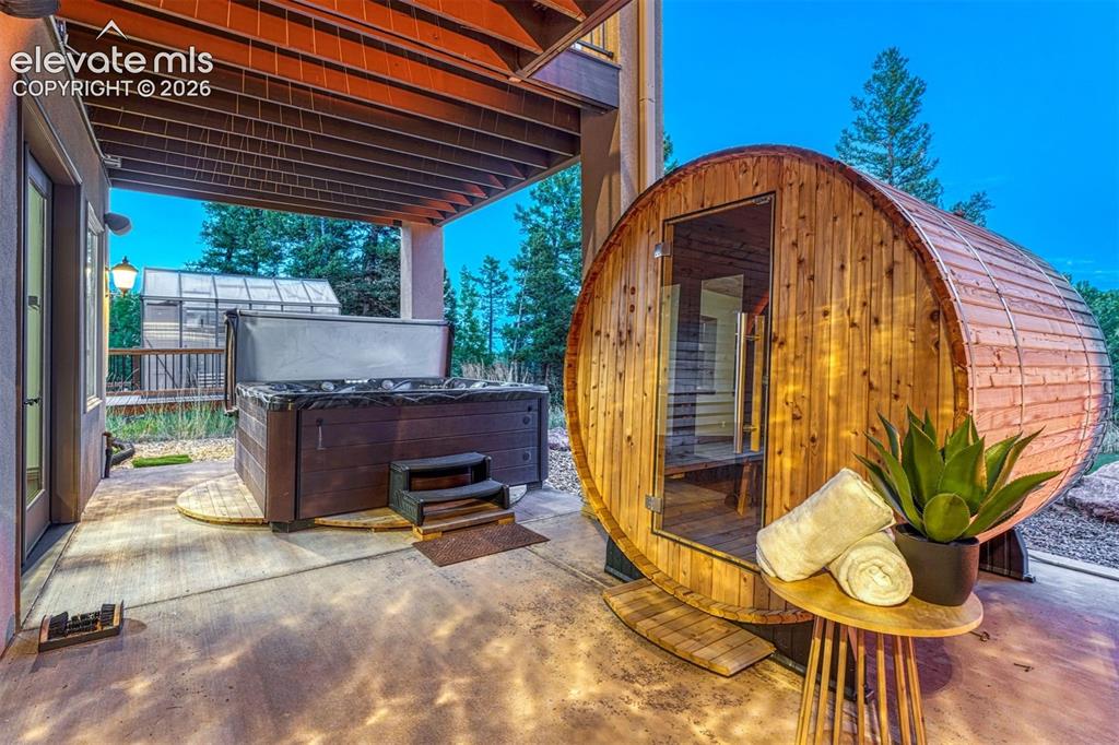 Image 40 of 50: Walk out patio to Sauna, hot tub and greenhouse
