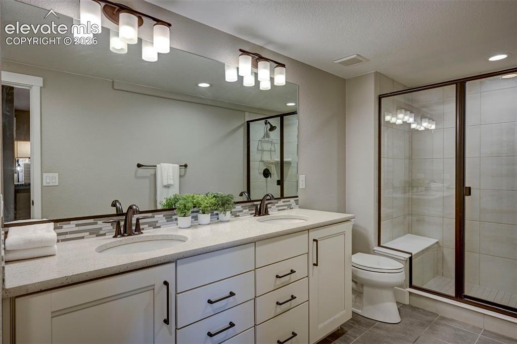 Image 45 of 50: Basement Full Bathroom with Double Sinks and a large linen closet.