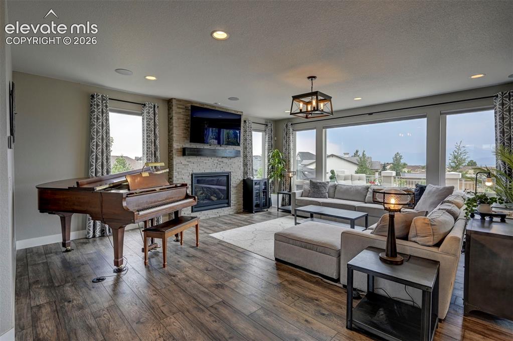 Image 8 of 50: Inviting living room with a gas fireplace, room for a beautiful piano and w