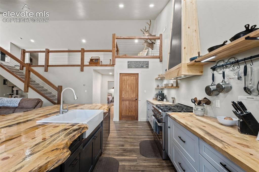 Image 15 of 42: Kitchen featuring a farmhouse sink, wood-finish countertops, stainless stee
