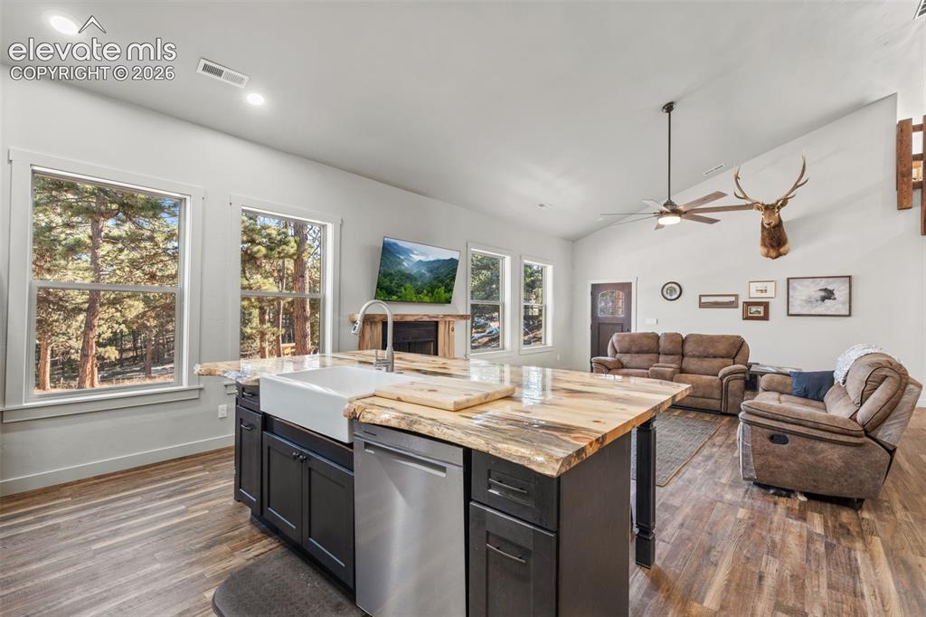 Image 17 of 42: Spacious kitchen island with a farmhouse sink and unique wood-finish counte