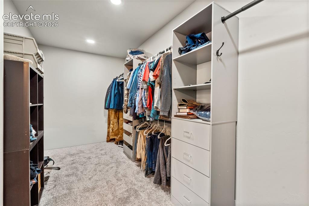 Image 25 of 42: Custom closet system with integrated shelving, multiple drawers, and hangin