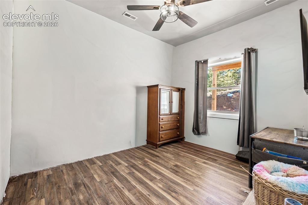 Image 30 of 42: Wood-finish flooring, white walls, and a ceiling fan with integrated lighti