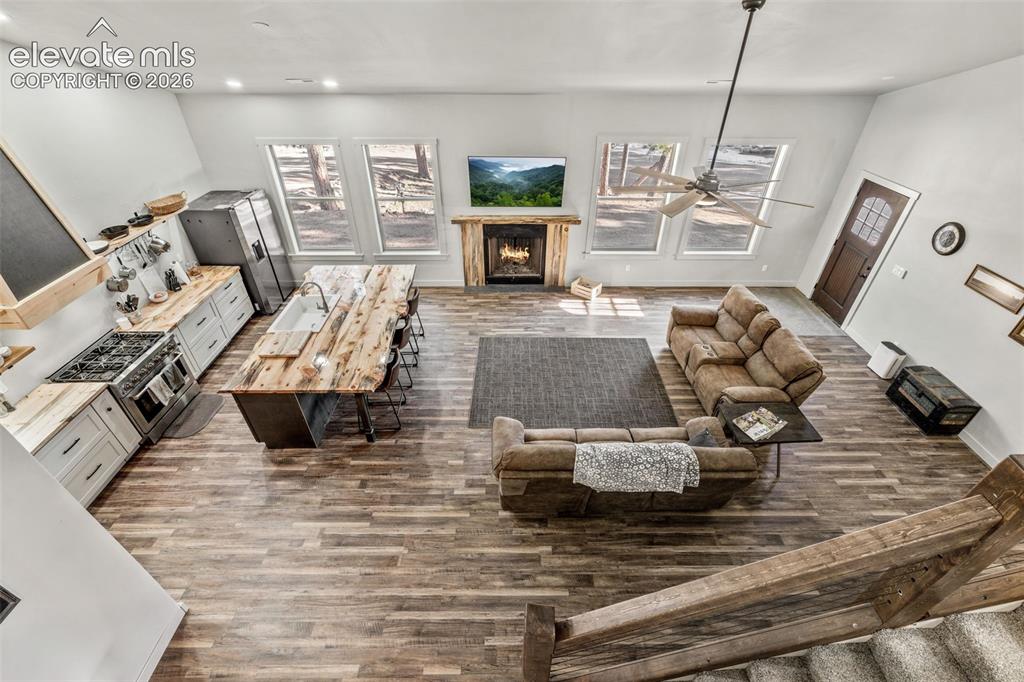 Image 34 of 42: Vaulted ceiling with an exposed beam, wood-finish flooring, built-in firepl