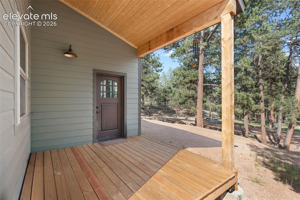 Image 5 of 42: Expansive wood deck with a natural wood ceiling, wood support beam, and dur