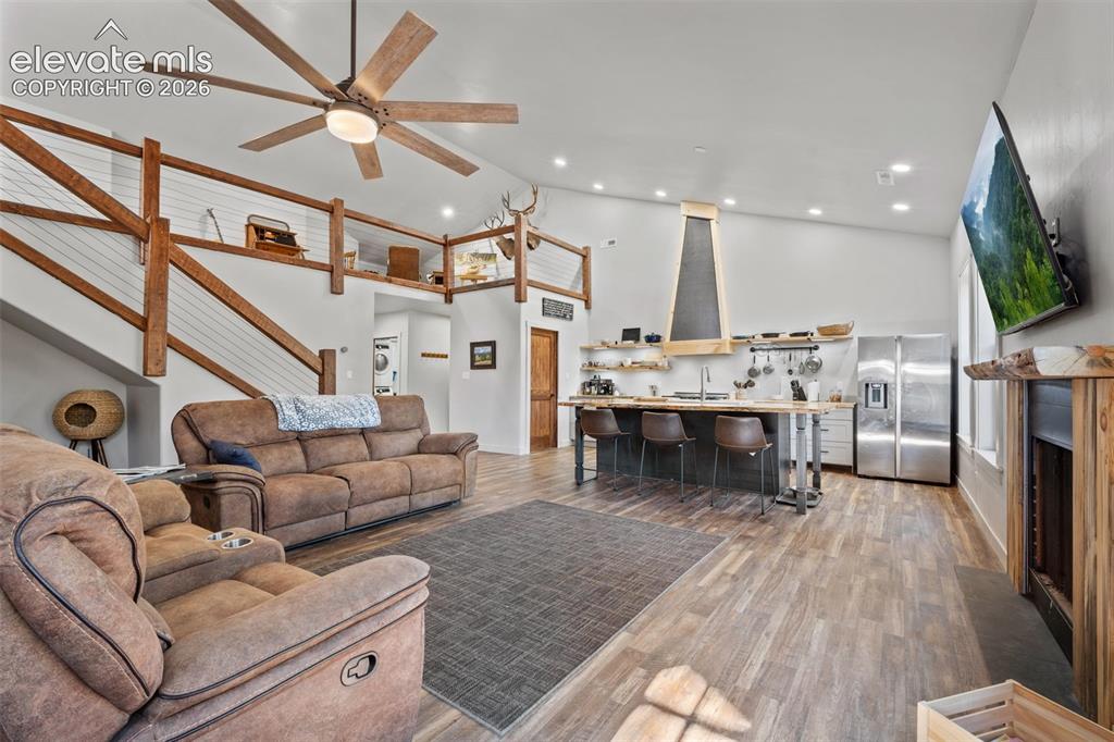 Image 7 of 42: Vaulted ceiling with wood-finish ceiling fan, wood-finish flooring, custom 