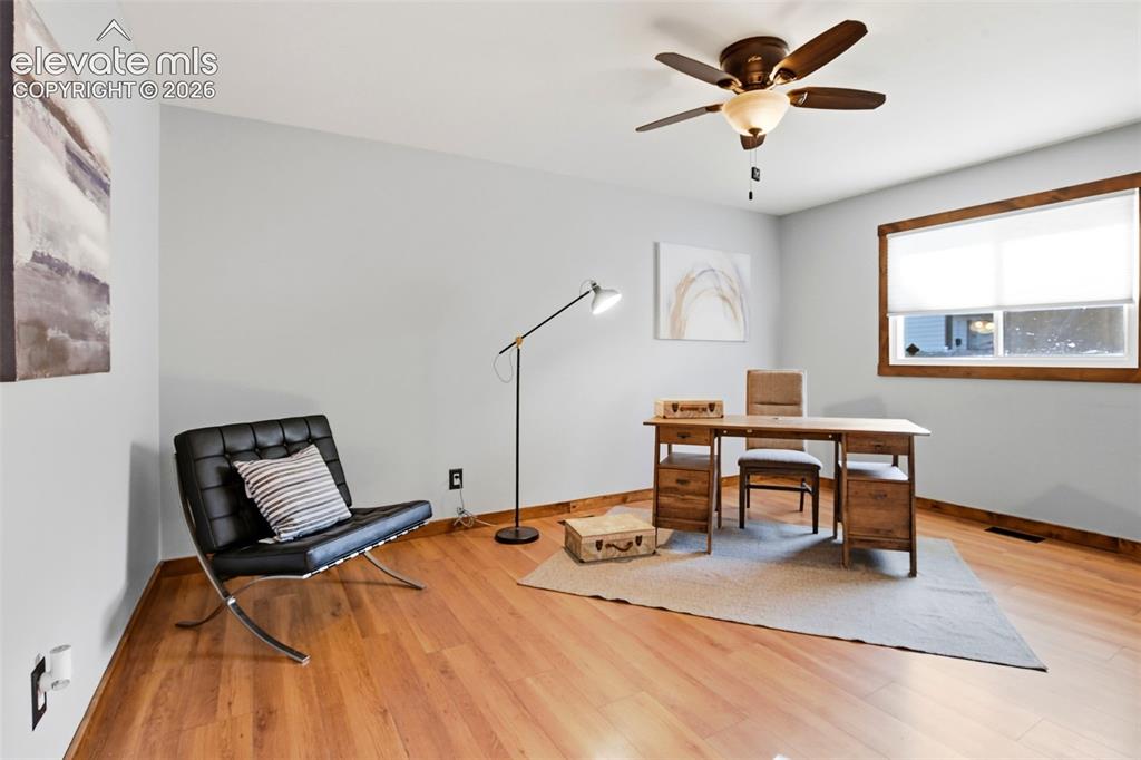Image 24 of 50: This is staged as an office, but is a bedroom. It uses the bathroom down t