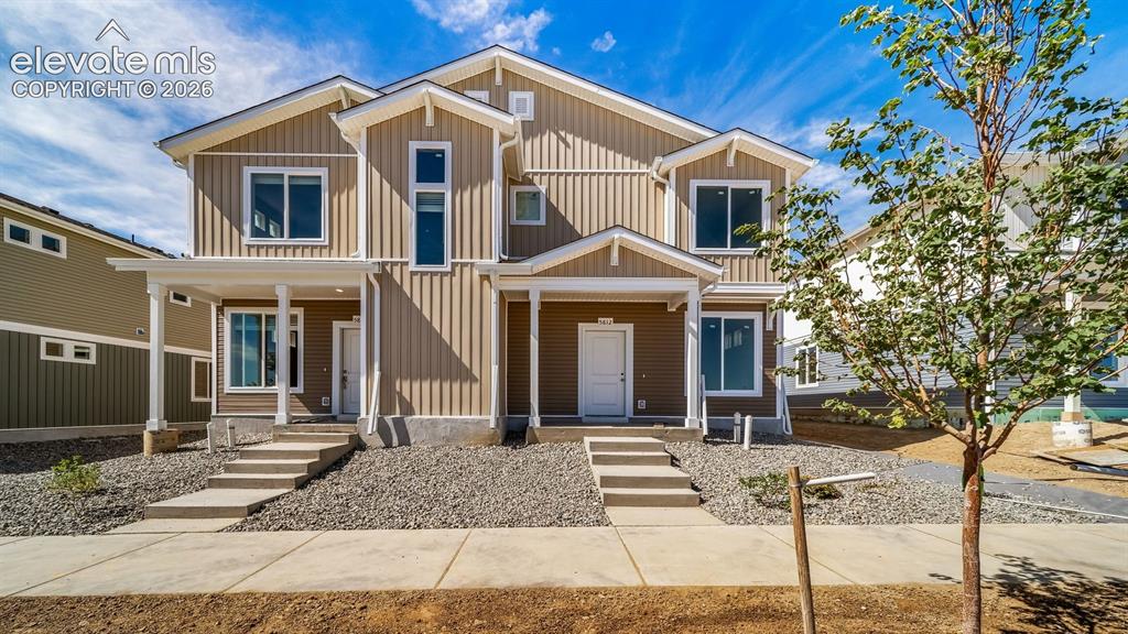Image 1 of 22: with two stories, board and batten siding, covered front porches, concrete
