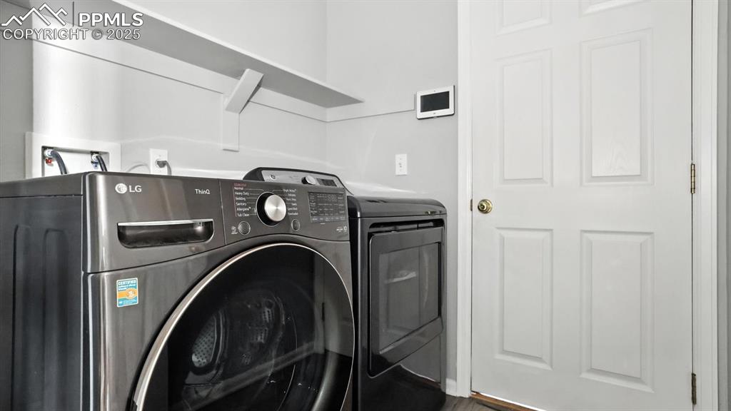 Image 12 of 26: Laundry Room with garage access and washer and dryer that stay.