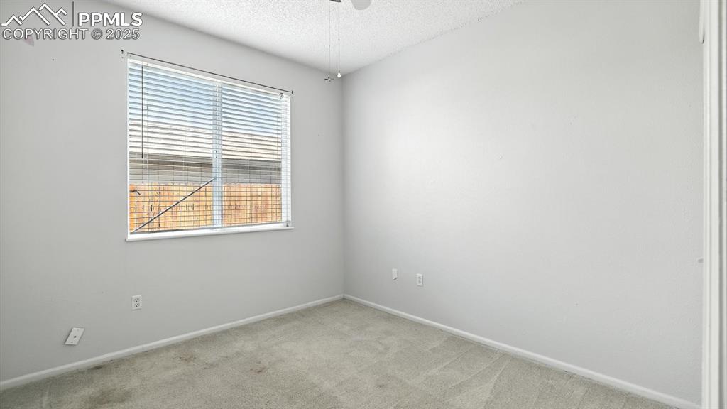 Image 13 of 26: Vaulted Bedroom #2 with lighted ceiling fan and neutral carpet.