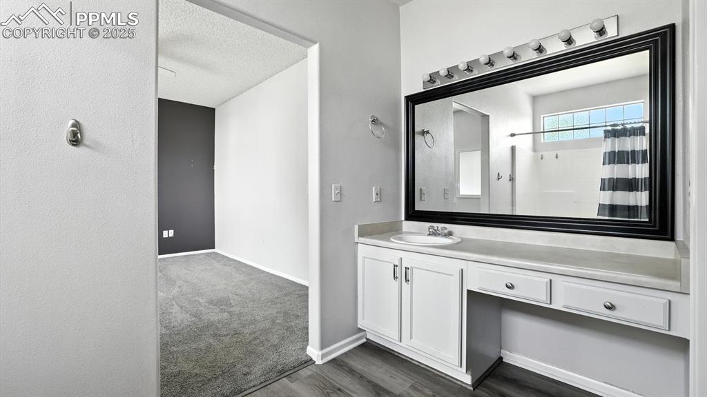 Image 17 of 26: Primary Bathroom extended vanity with seated makeup area and framed mirror.