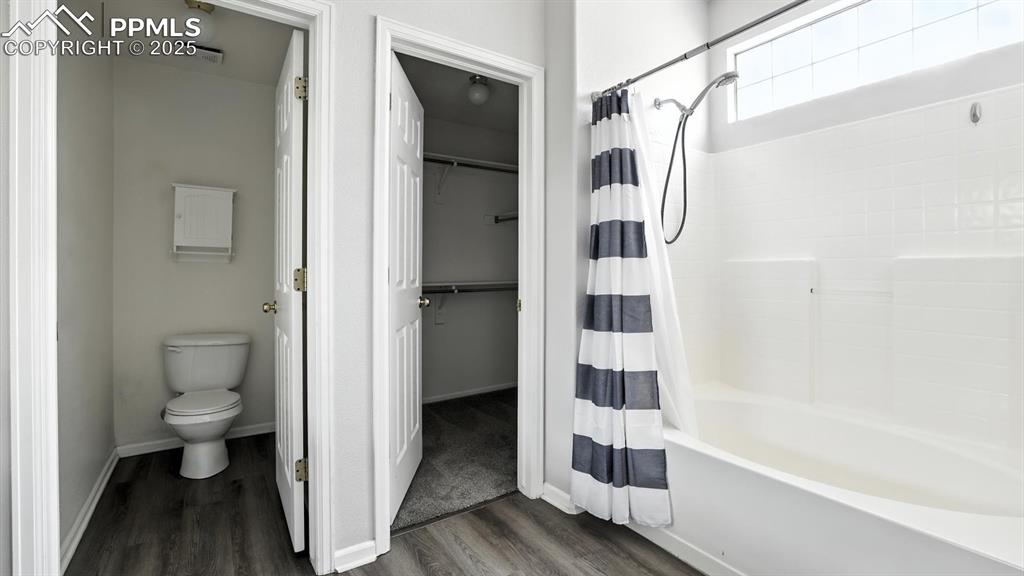 Image 18 of 26: Tub/shower, walk in closet, and toilet area in the Primary Bathroom.