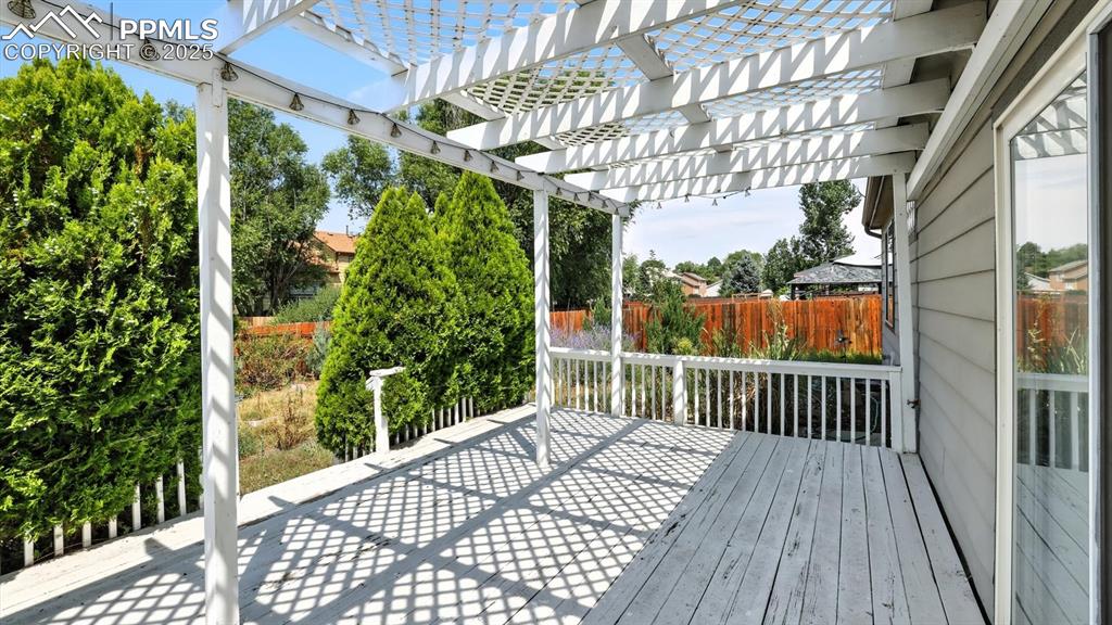 Image 19 of 26: Backyard deck with partially covered pergola for outdoor dining and relaxat