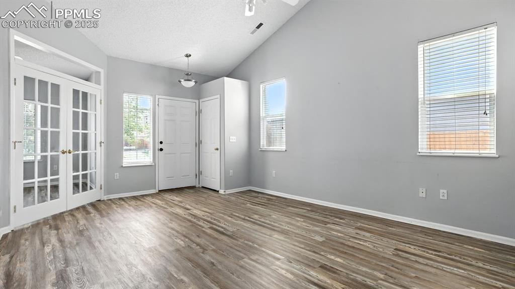 Image 5 of 26: Spacious Living Room, with vaulted ceilings, double windows, and an entry c