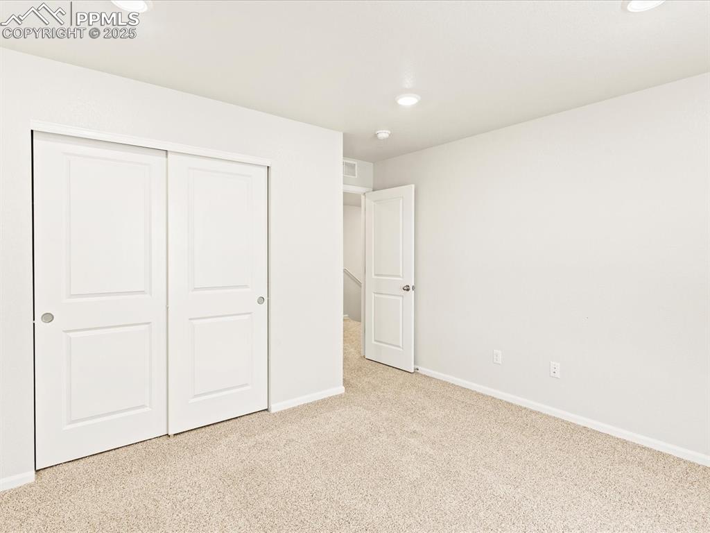 Image 21 of 32: Unfurnished bedroom with carpet flooring, a closet, and recessed lighting
