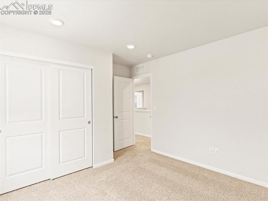 Image 24 of 32: Unfurnished bedroom with carpet floors, a closet, and recessed lighting