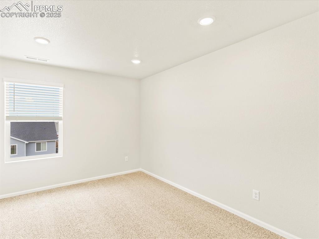 Image 25 of 32: Carpeted spare room with baseboards and recessed lighting
