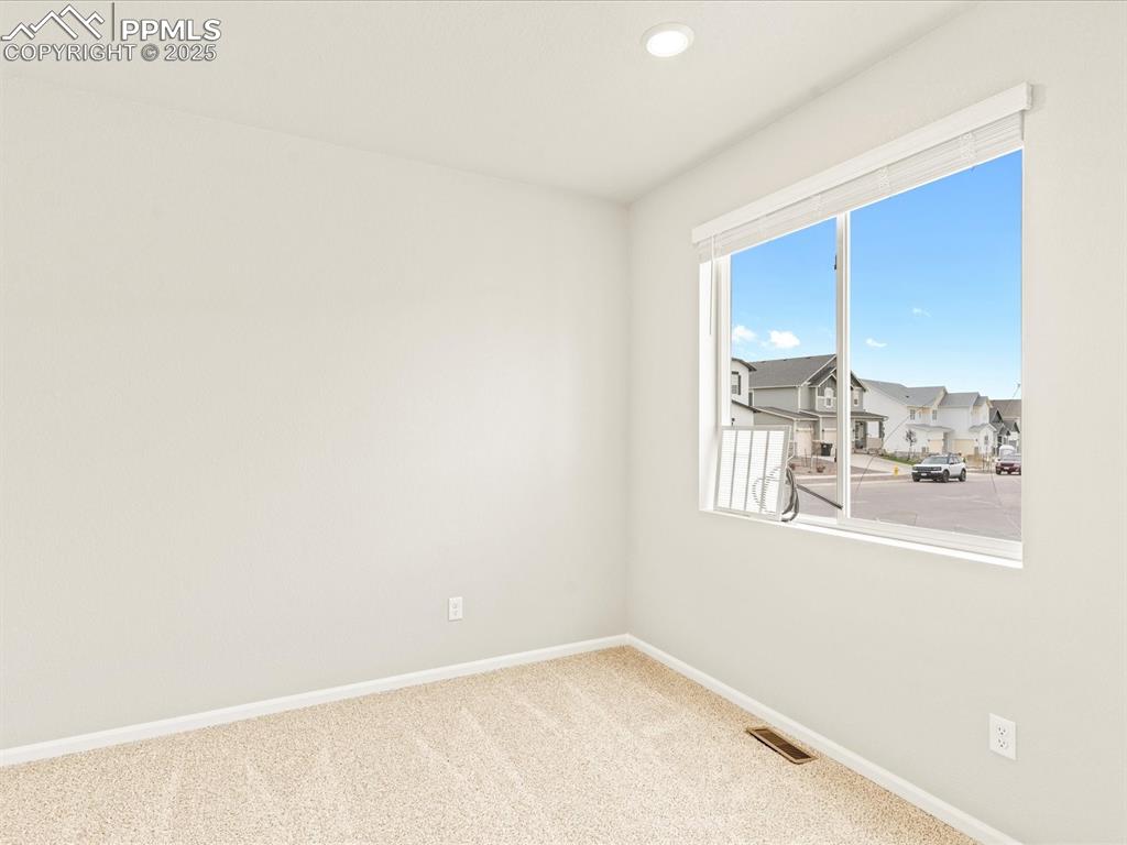 Image 28 of 32: Carpeted spare room featuring a residential view and recessed lighting