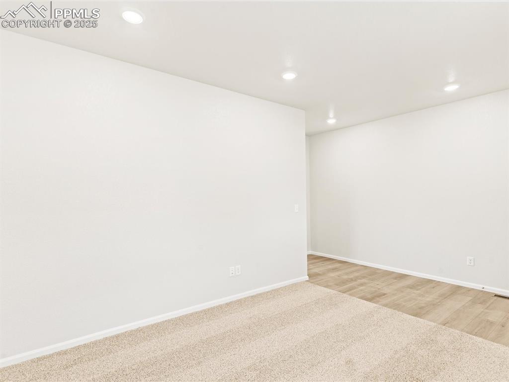Image 3 of 32: Unfurnished room with recessed lighting, carpet, and wood finished floors