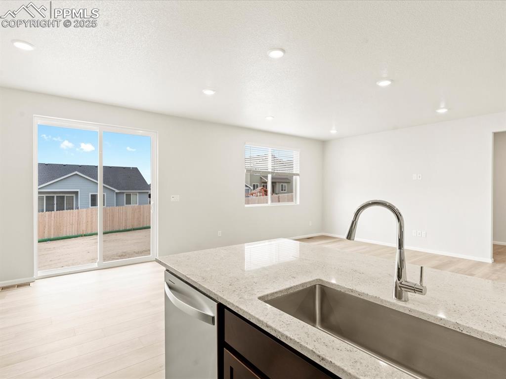 Image 5 of 32: Kitchen featuring light wood finished floors, light stone counters, healthy