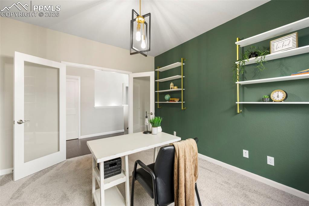 Image 29 of 49: Office with light colored carpet and baseboards