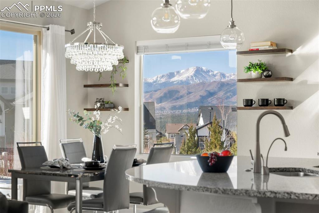 Image 3 of 49: Dining room with hanging lights and a mountain view